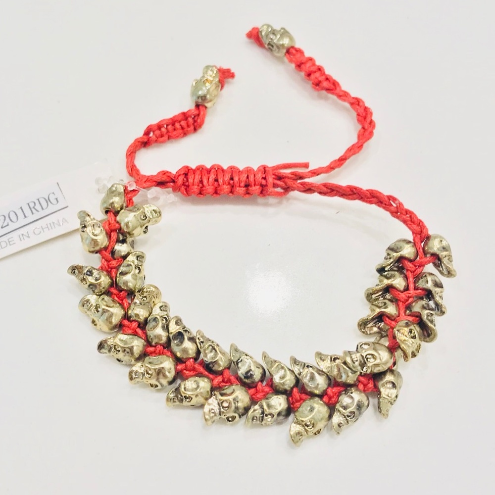 NWT bracelet, multiple bronze skulls & red thread